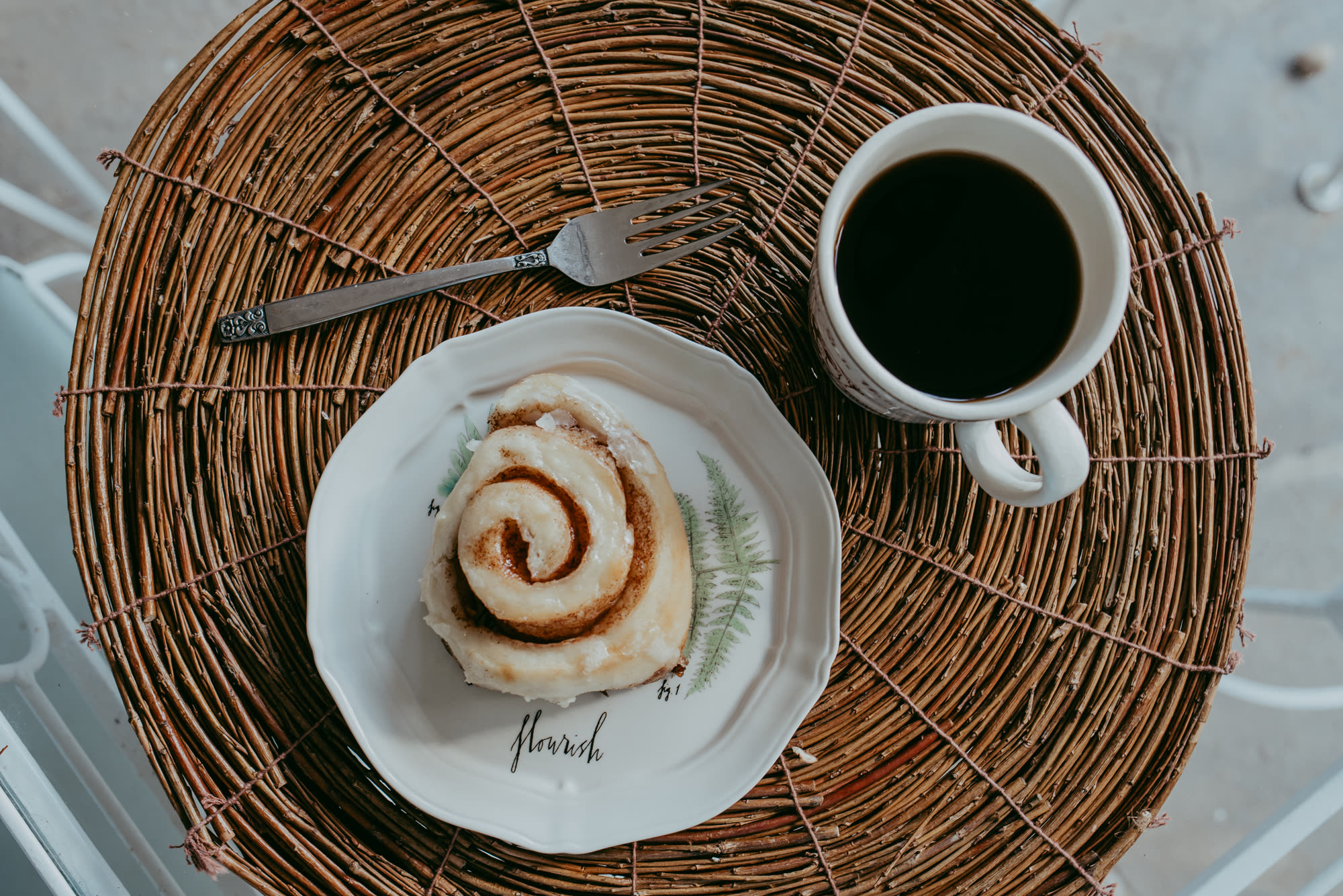 A LoveLee cinnamon roll plated with coffee, ready to gift